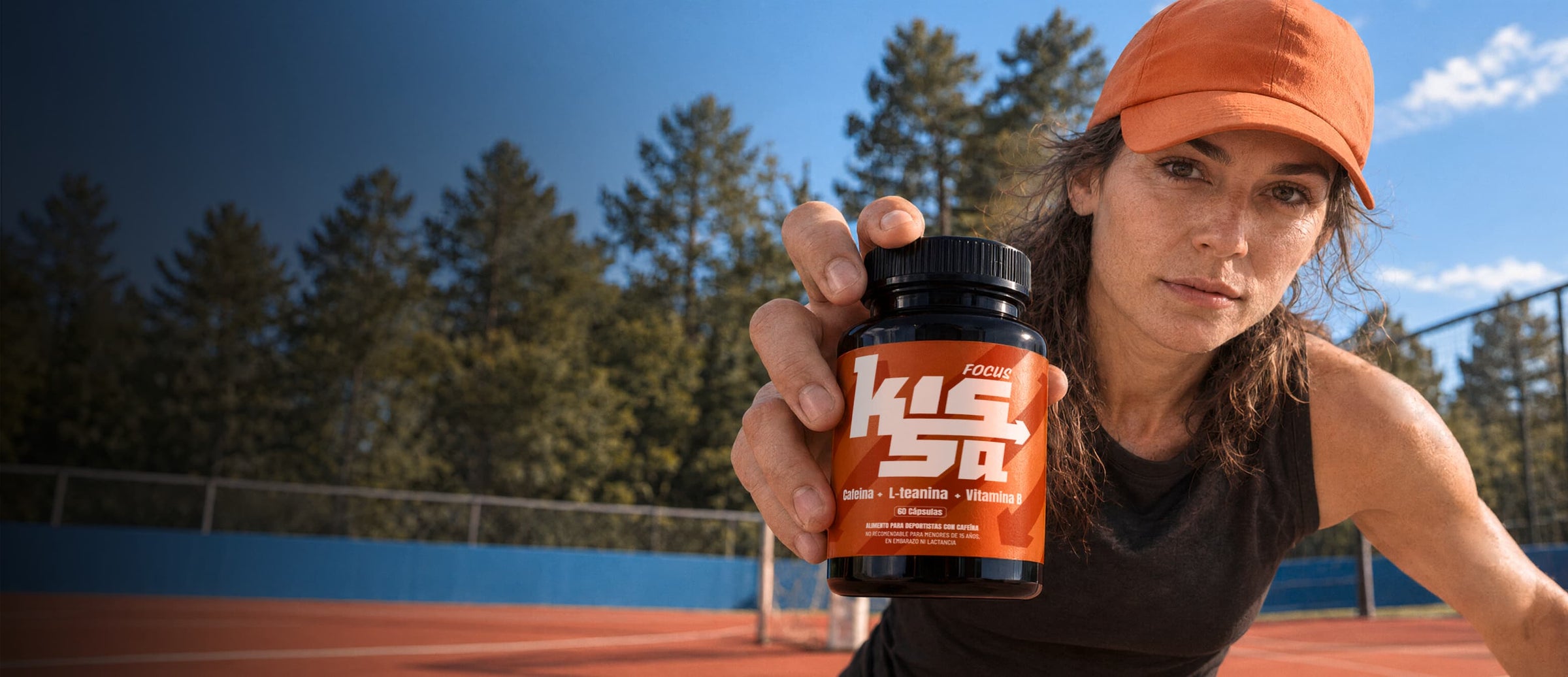 Mujer en una cancha al aire libre mostrando un frasco de Focus Kissa
